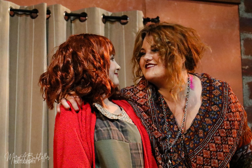 Annie — Miss Hannigan puts her arm around Annie in an intimate scene