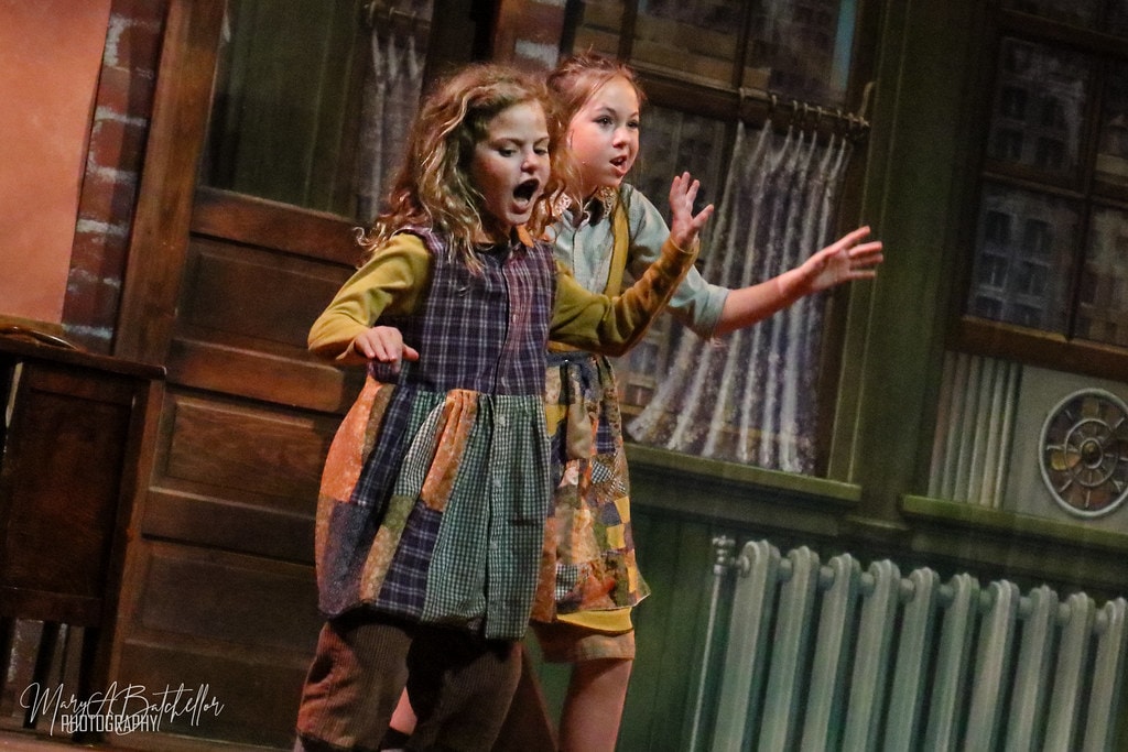 Annie — two young orphan girls react with open-mouthed shock in the orphanage set