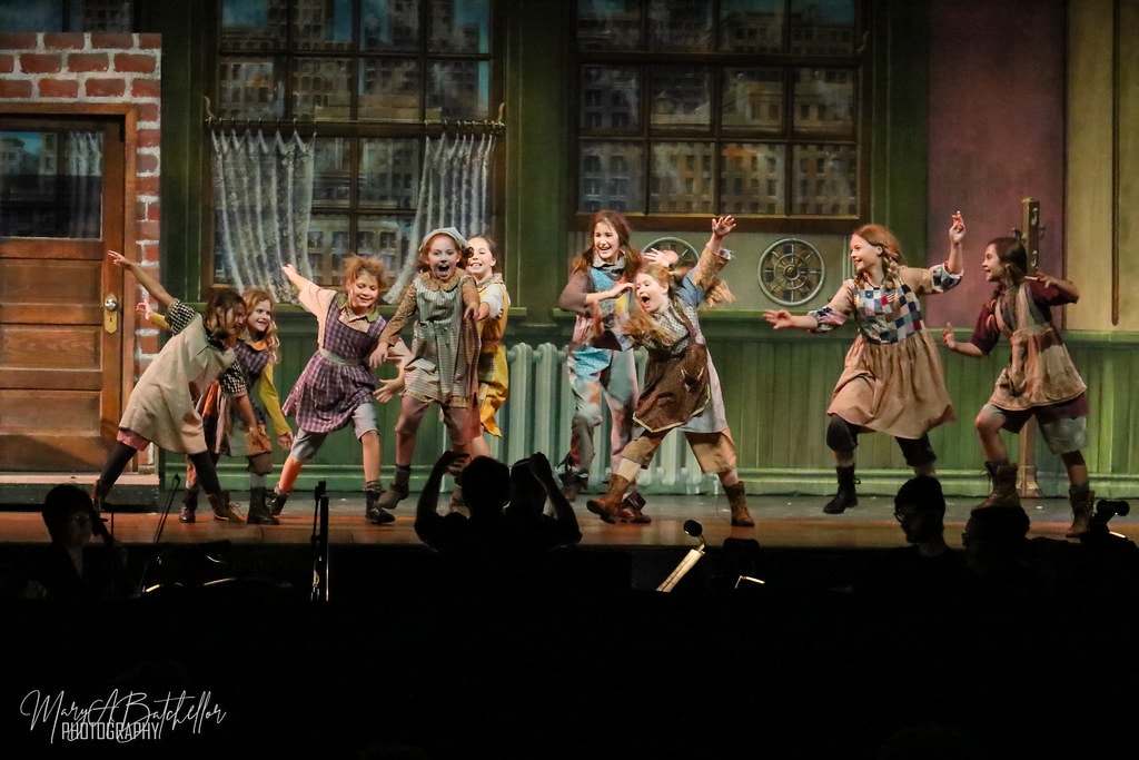 Annie — ten orphan girls dance in a wide formation before the Warbucks apartment set