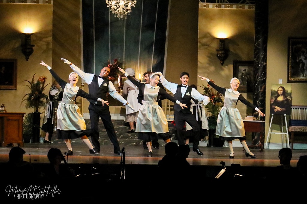 Annie — six Warbucks mansion servants in silver aprons leap with arms outstretched