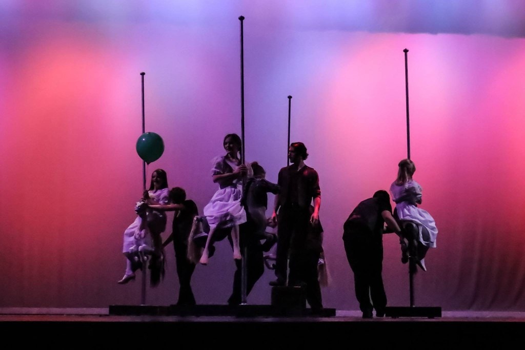 Silhouetted carousel pole riders against pink and purple backdrop — Carousel