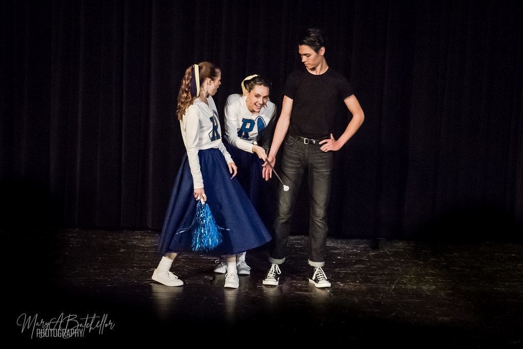 Grease — two Rydell cheerleaders with batons flirting with Danny