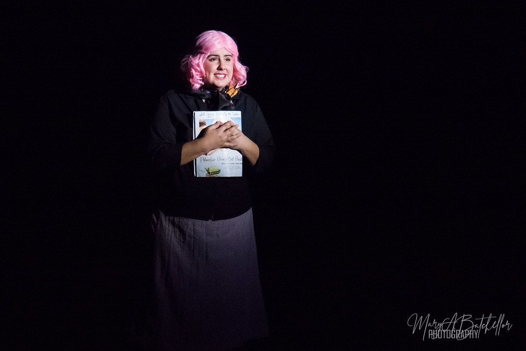 Grease — Frenchie in pink wig holding beauty school books