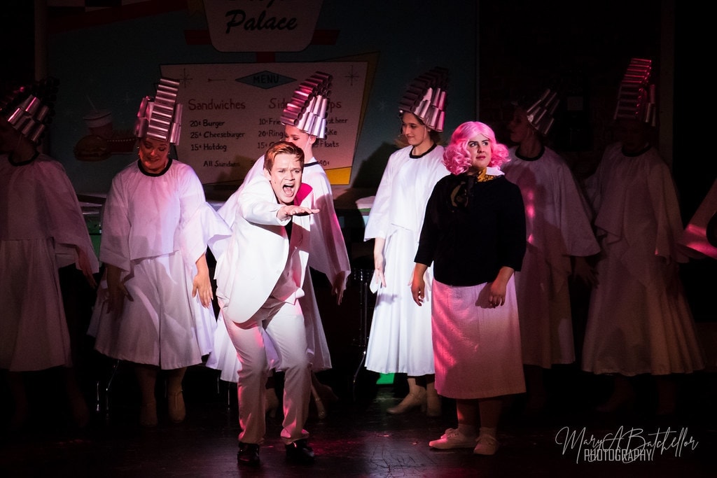 Grease — Teen Angel in white suit belting to audience with Frenchie