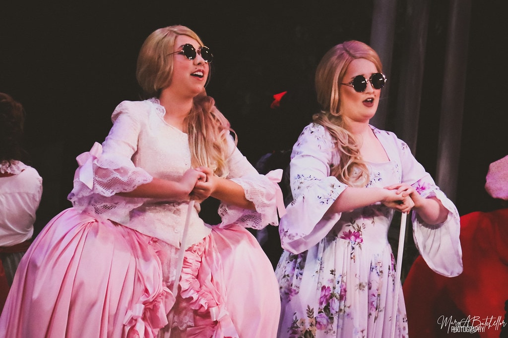 Into the Woods — Cinderella's two stepsisters in pink gowns and round sunglasses perform a comedic number