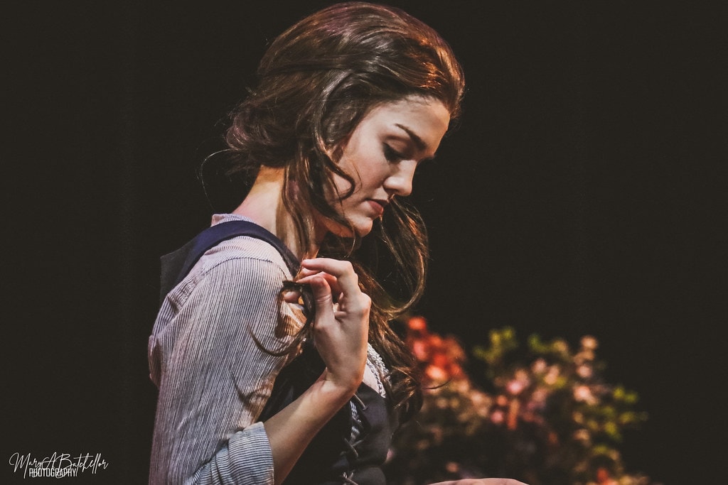 Into the Woods — the Baker's Wife in a close-up portrait looking down pensively in the enchanted forest