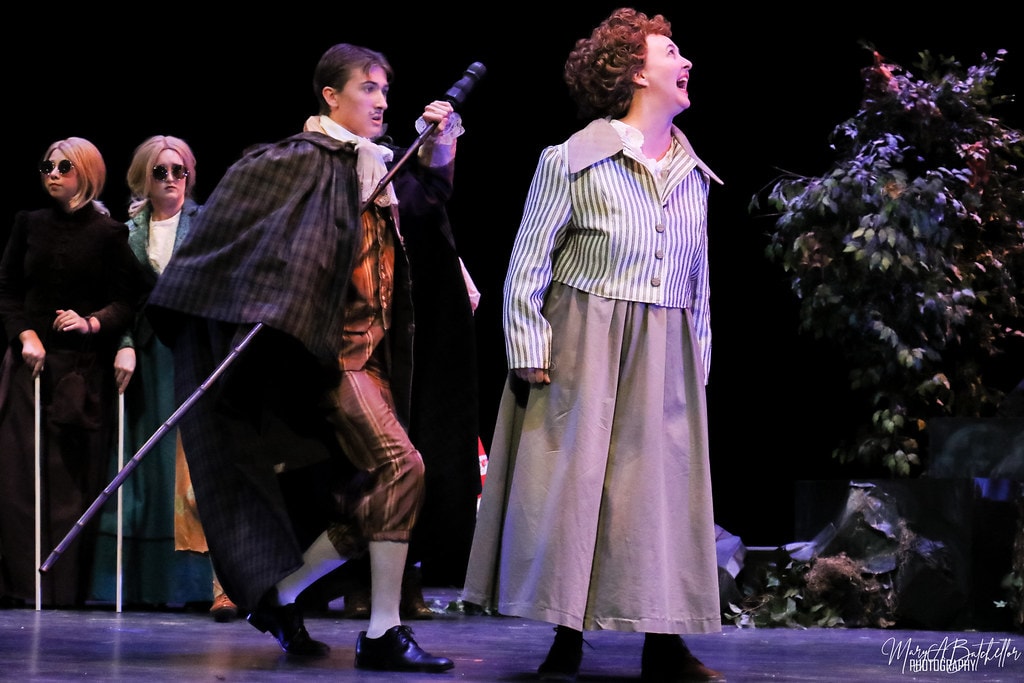 Into the Woods — the Mysterious Man with a staff and the Baker's Wife sing together before the forest foliage