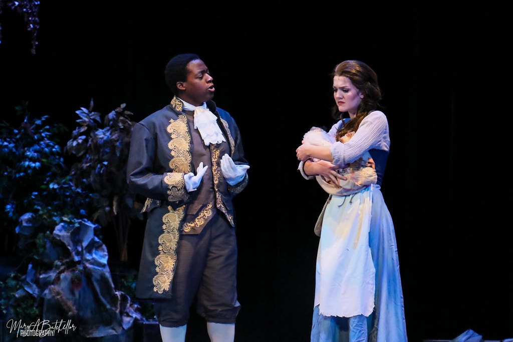 Into the Woods — Cinderella's Prince in a gold-embroidered jacket sings to the Baker's Wife who holds a baby in the blue-lit forest