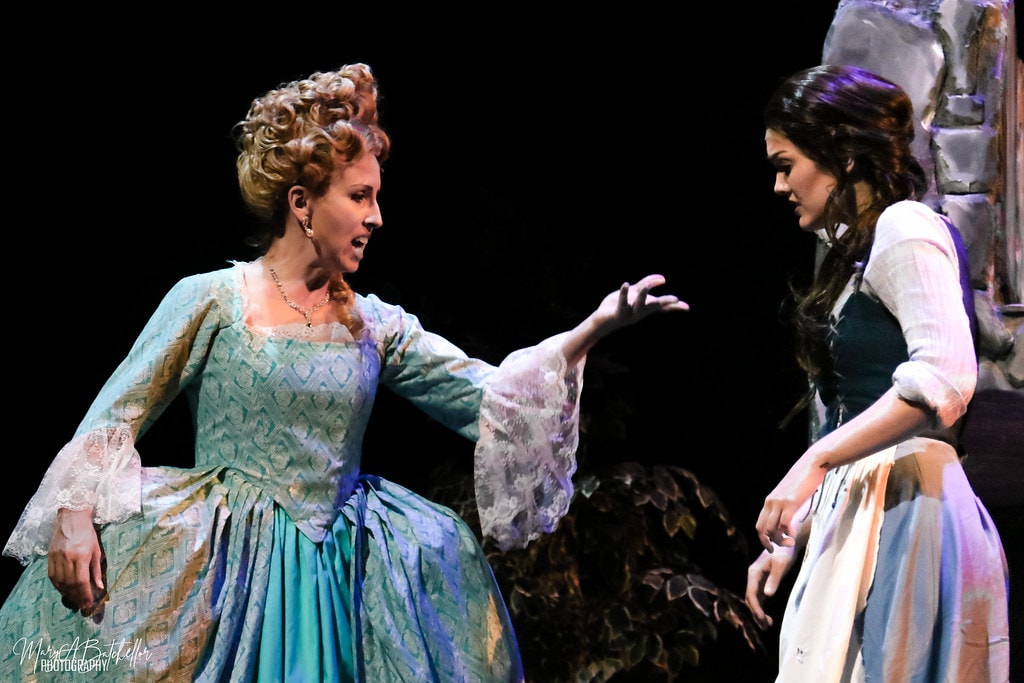 Into the Woods — Cinderella's stepmother in a teal brocade gown confronts the Baker's Wife in a dramatic face-off