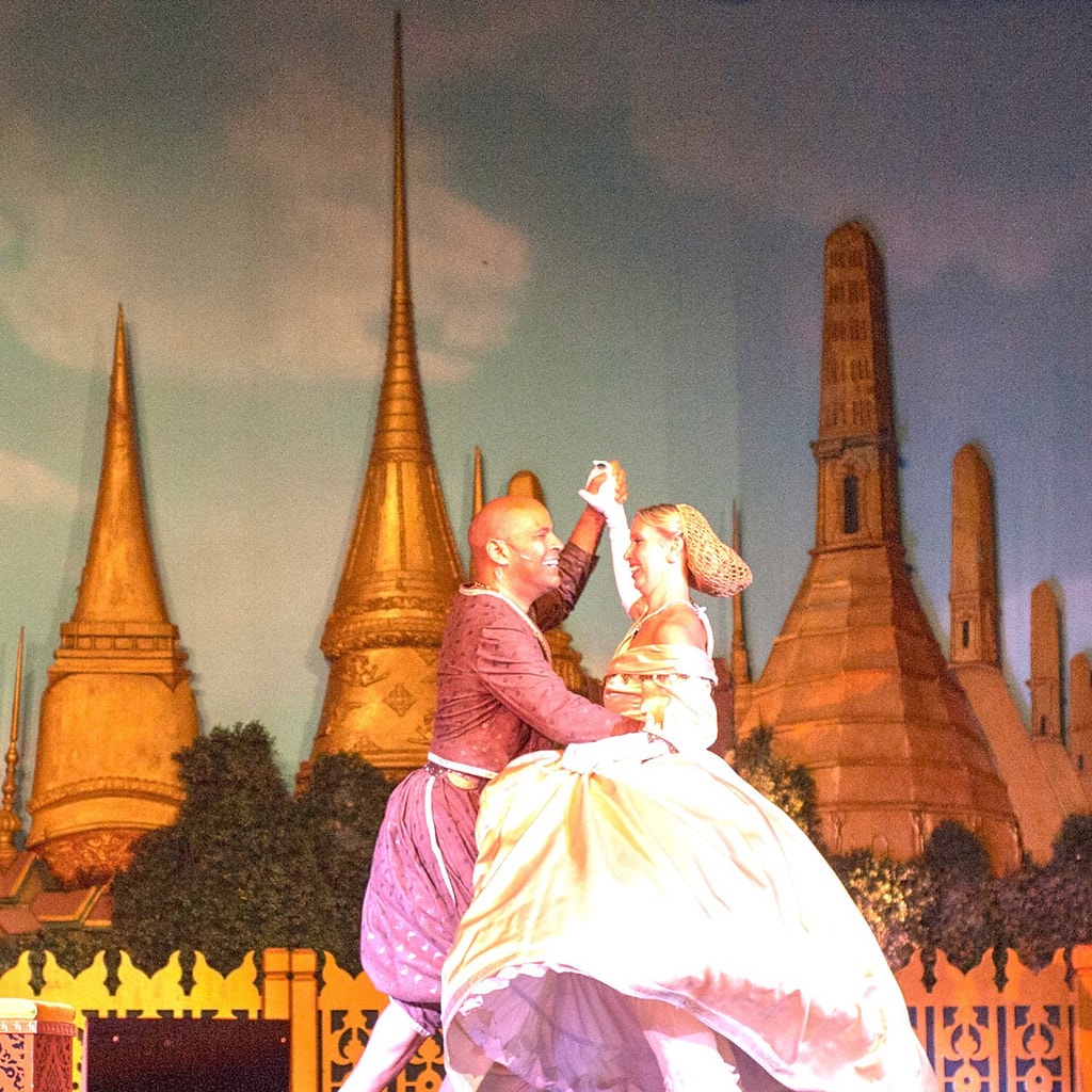 The King & I — the King and Anna dancing together before the painted Bangkok skyline backdrop