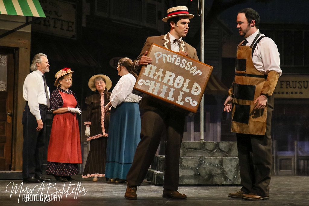 The Music Man — Harold Hill holds his Professor Harold Hill suitcase sign