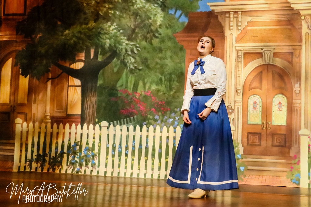 The Music Man — Marian belts a solo before the painted Victorian house backdrop