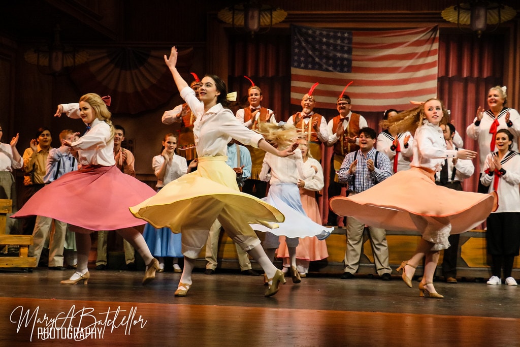 The Music Man — three young women in pastel skirts spin and twirl