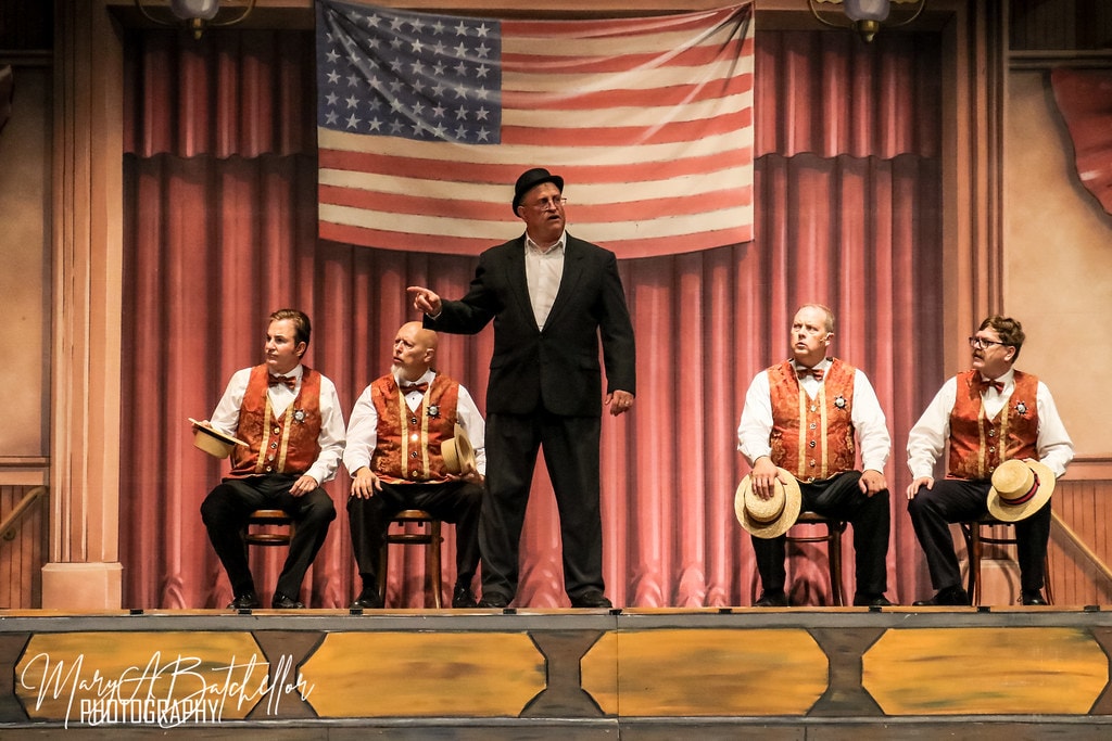 The Music Man — Mayor Shinn points at four men in red brocade vests