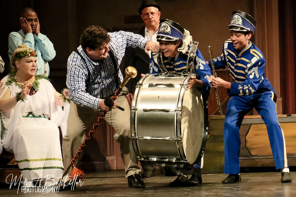 The Music Man — Harold Hill and two boys in blue marching band uniforms wrestle over a bass drum