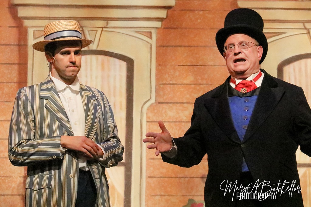 The Music Man — Harold Hill and Mayor Shinn face each other before the River City storefront