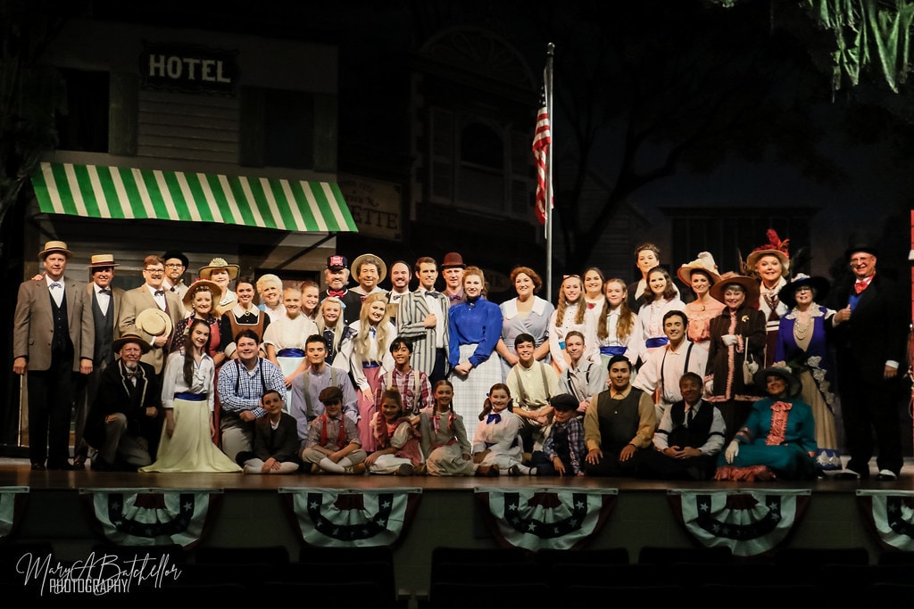 The Music Man — the full cast poses for a company photo before the River City Hotel backdrop