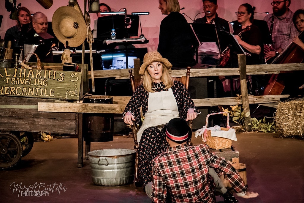 Oklahoma! — Ado Annie seated in rocking chair with arms wide
