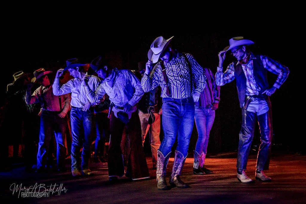 Oklahoma! — cowboys dancing under blue stage lights