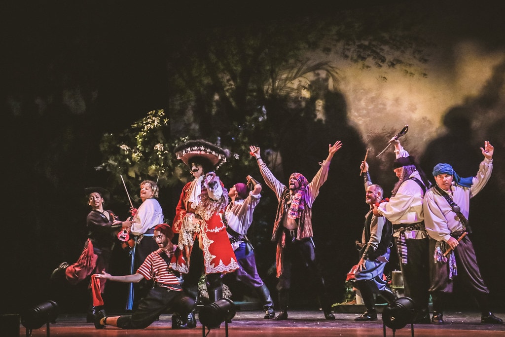 Peter Pan — Hook and his scallawags celebrate with swords raised in the jungle set