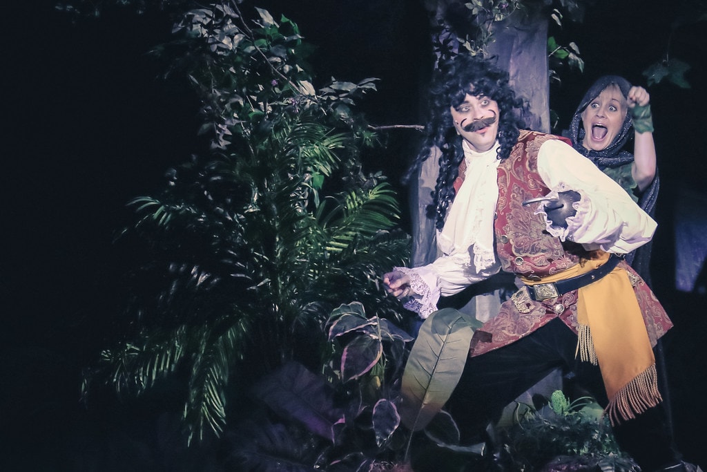 Peter Pan — Captain Hook and a companion lurk wide-eyed in the dark Neverland jungle foliage