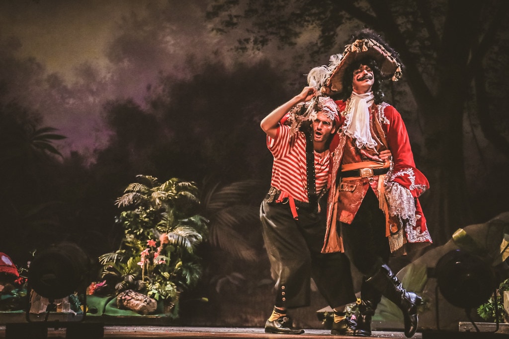 Peter Pan — Mr. Smee leans on Captain Hook as they perform a comedic duet in the purple-lit jungle