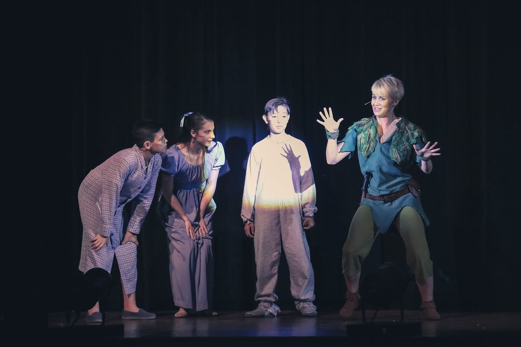 Peter Pan — Peter Pan teaches the Darling children how to crow on the darkened nursery stage
