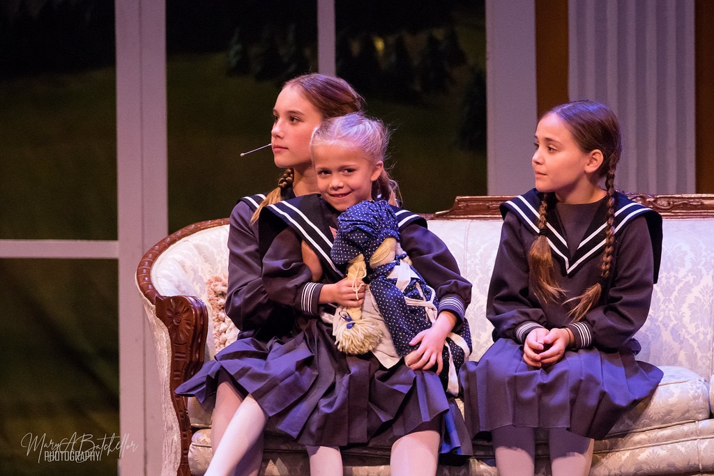 The Sound of Music — three von Trapp children seated on the parlor sofa