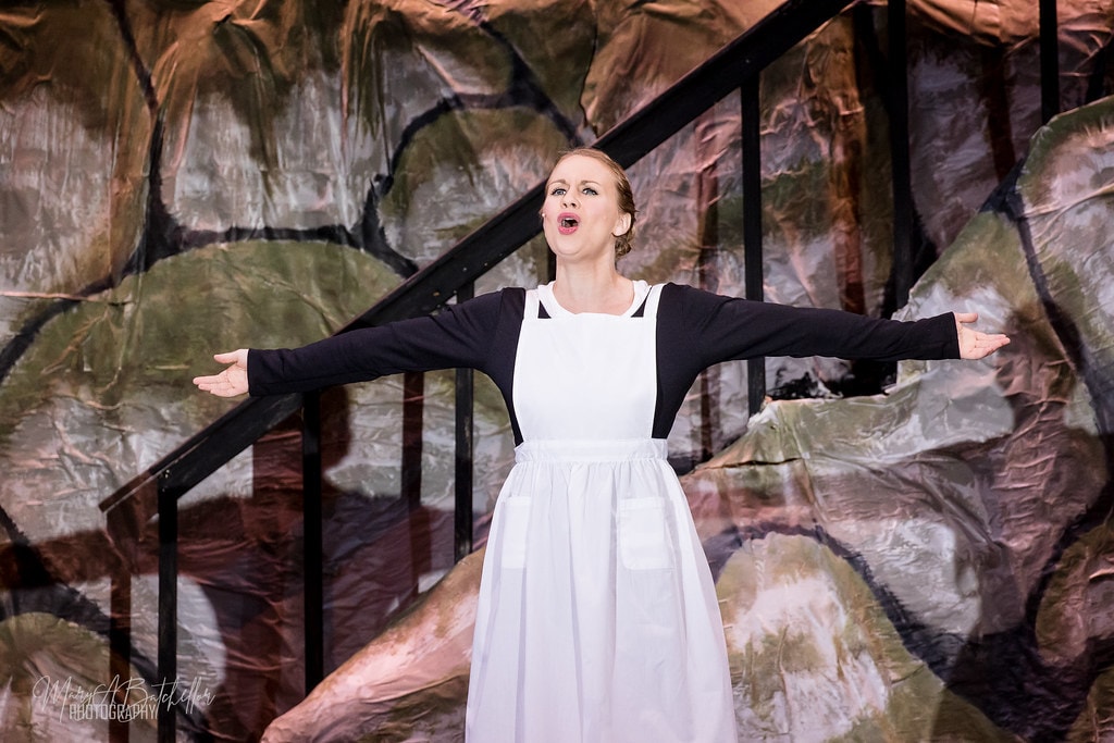 The Sound of Music — Maria in white apron singing with arms outstretched