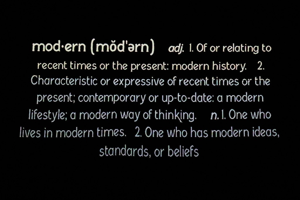 Thoroughly Modern Millie — dictionary definition of 'modern' projected on a black backdrop