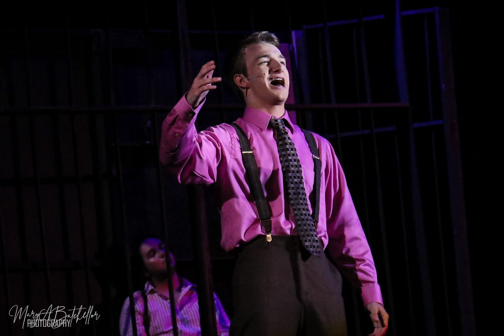 Thoroughly Modern Millie — a male performer in a pink shirt sings a solo