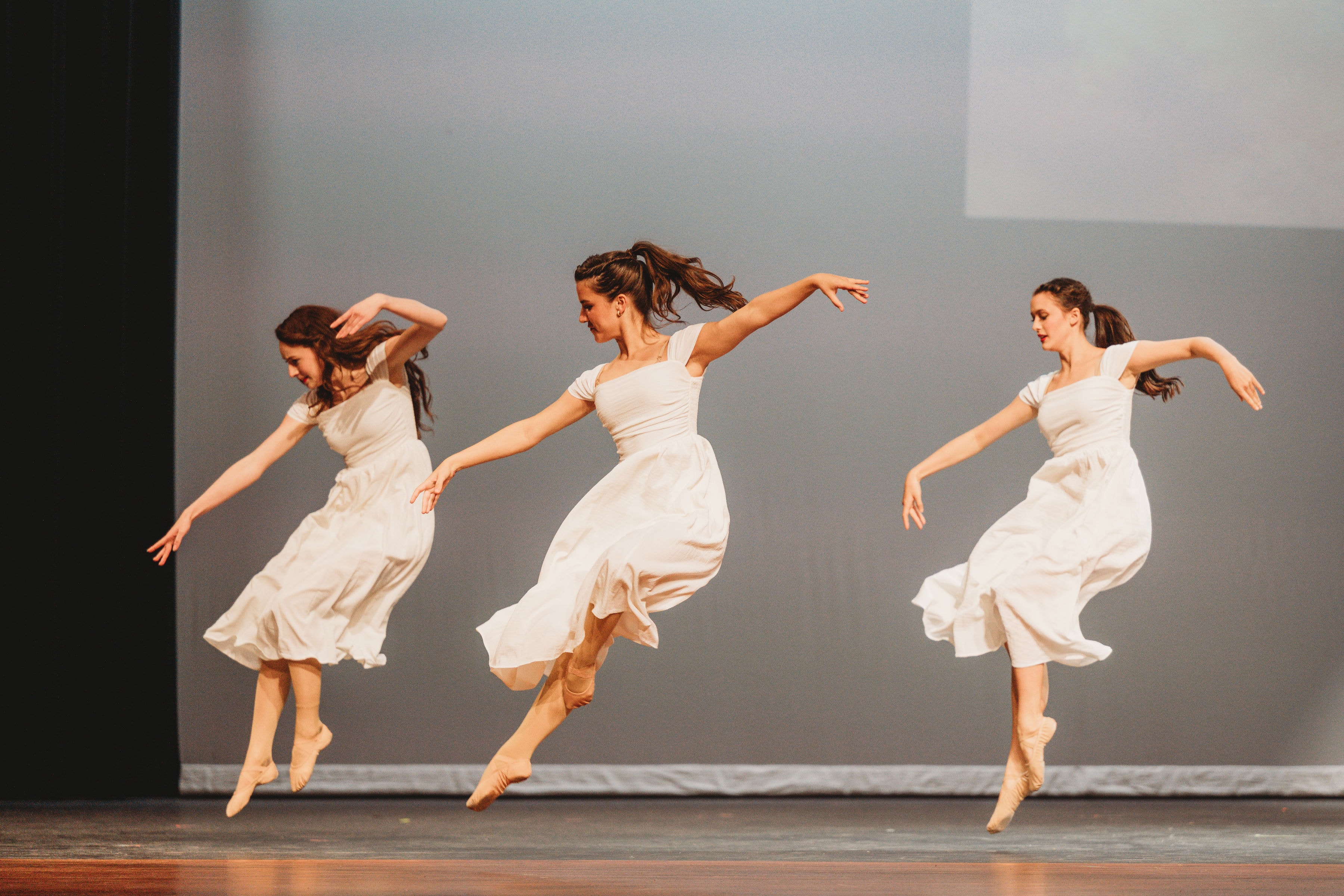West Side Story 2026 - three ballet dancers in white dresses leaping on stage