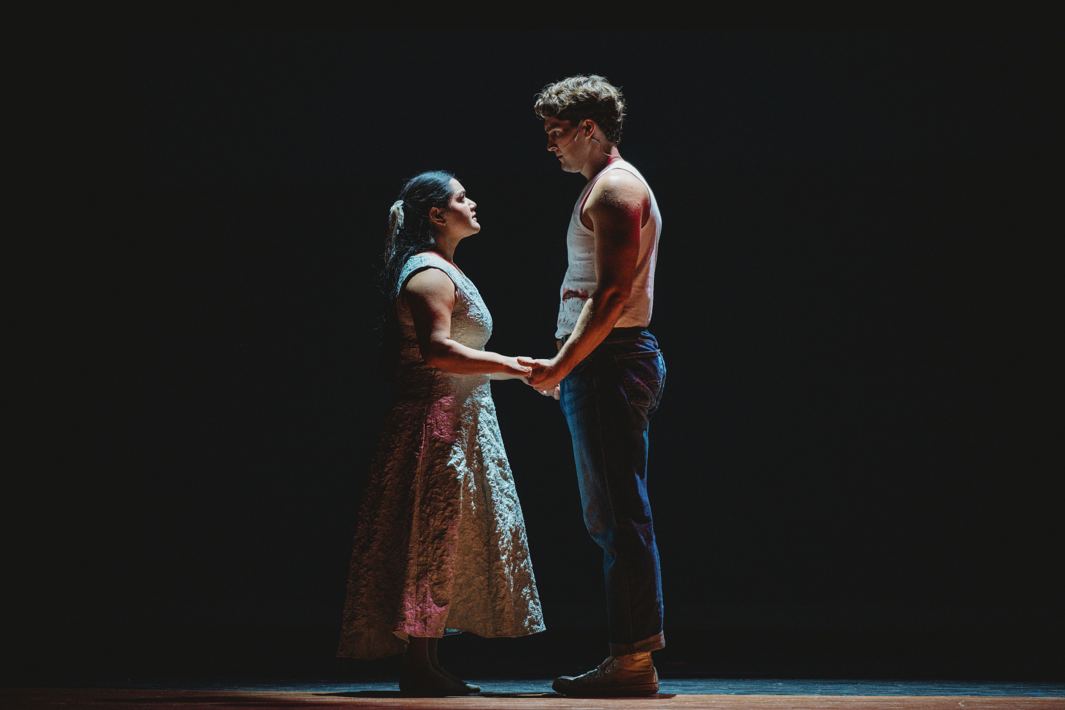 West Side Story 2026 - Maria and Tony holding hands in dramatic spotlight