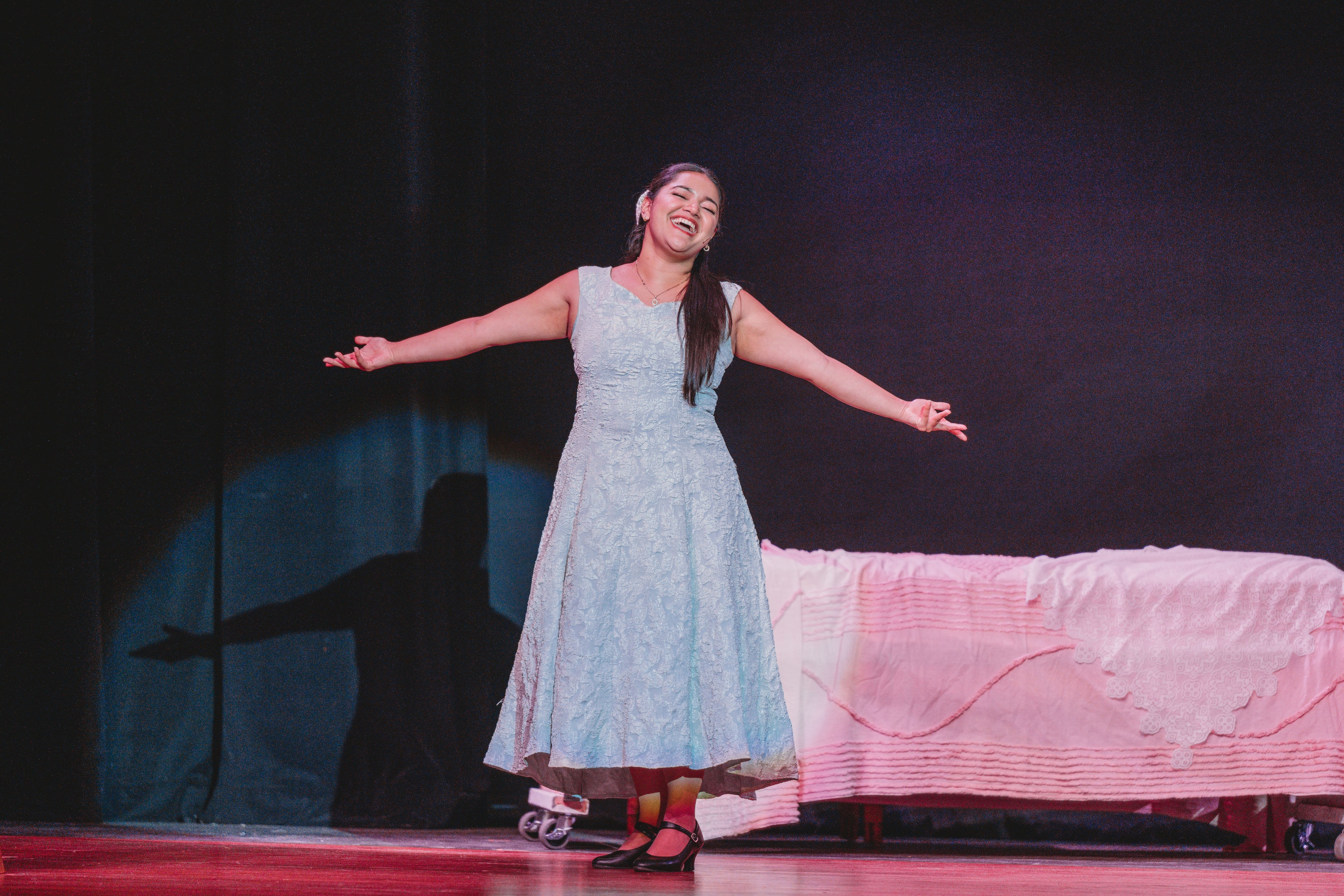 West Side Story 2026 - Maria singing with arms outstretched in blue dress