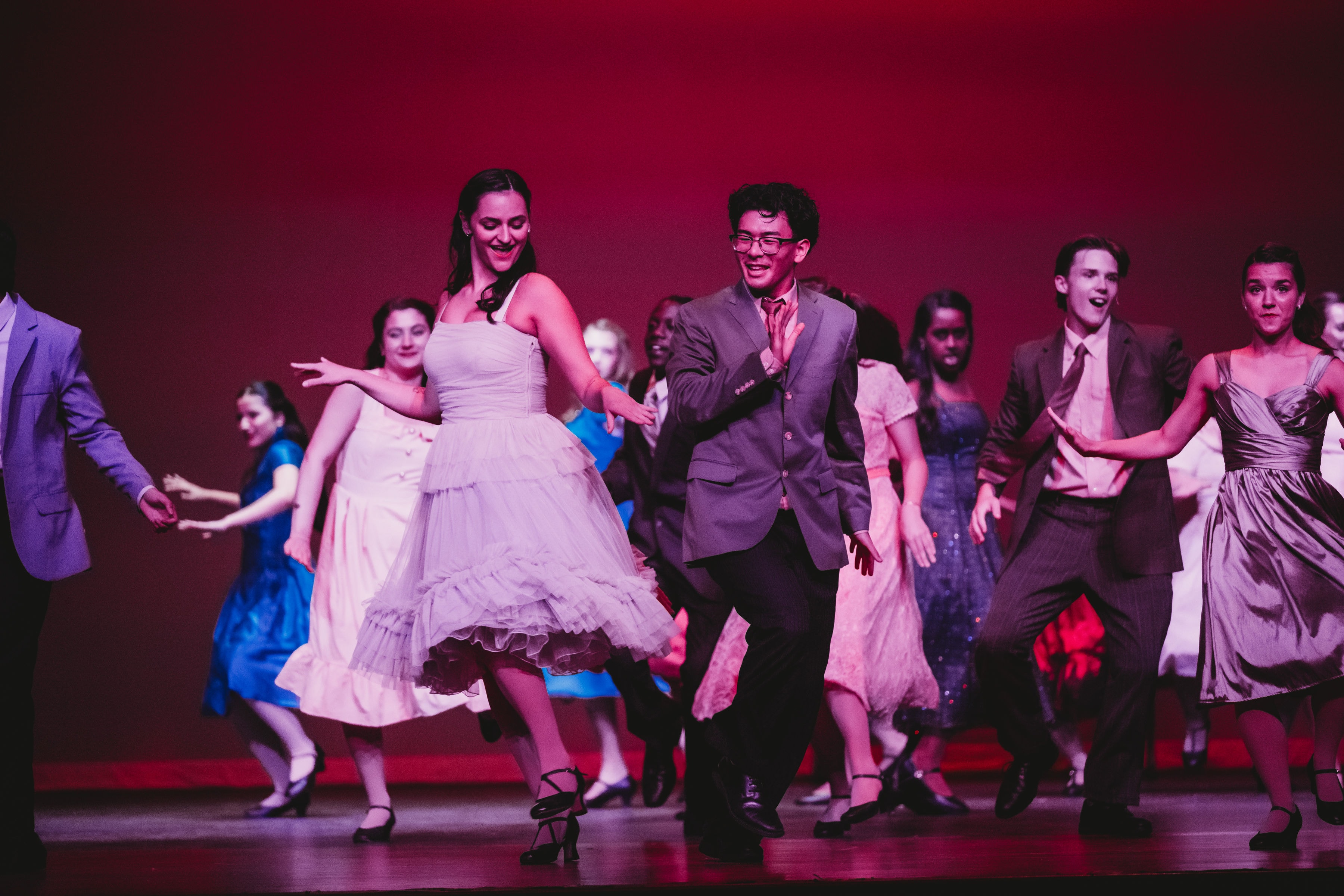 West Side Story 2026 - ensemble dance number with couples in red and purple lighting