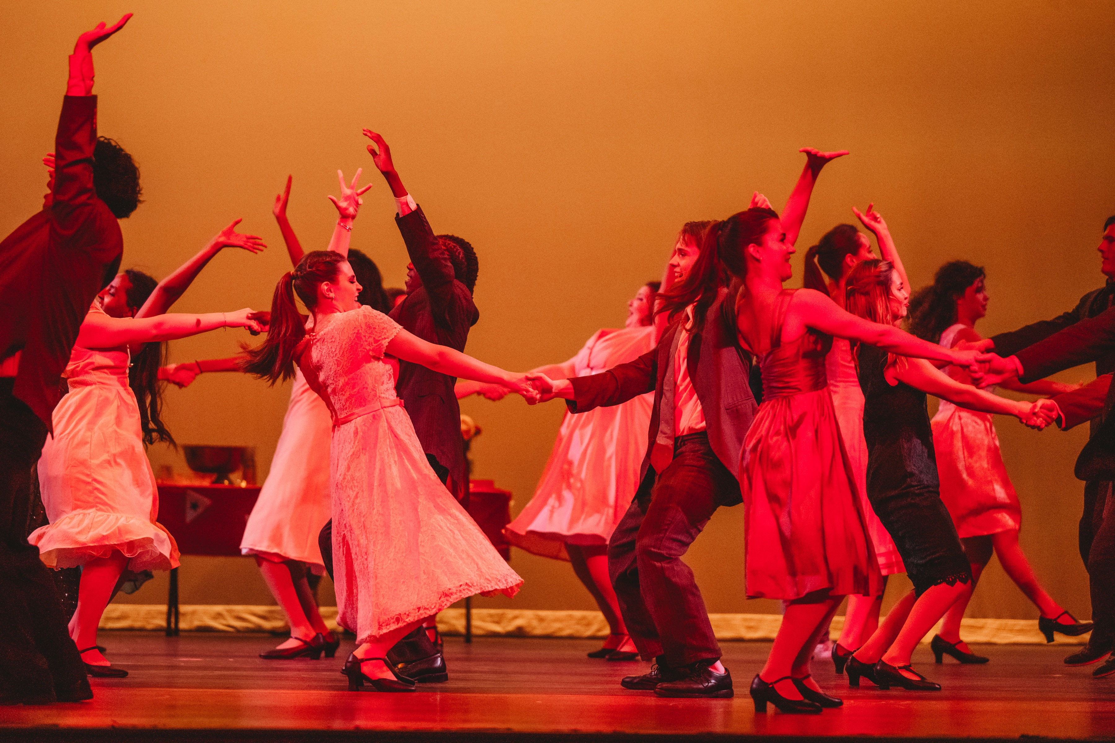 West Side Story 2026 - full cast dance number holding hands in warm red lighting